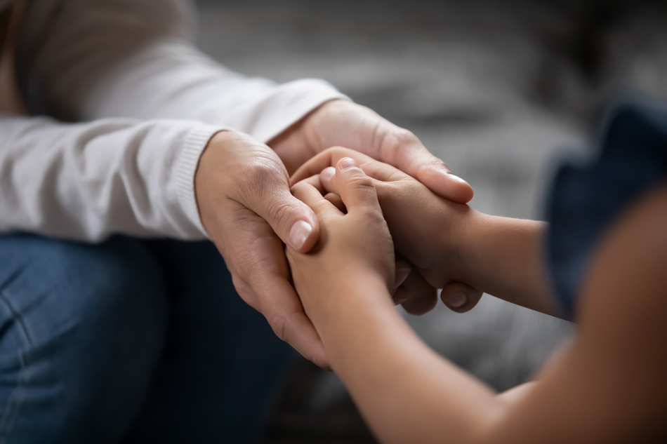Membro da família com problemas familiares segurando a mão de uma criança com TDAH