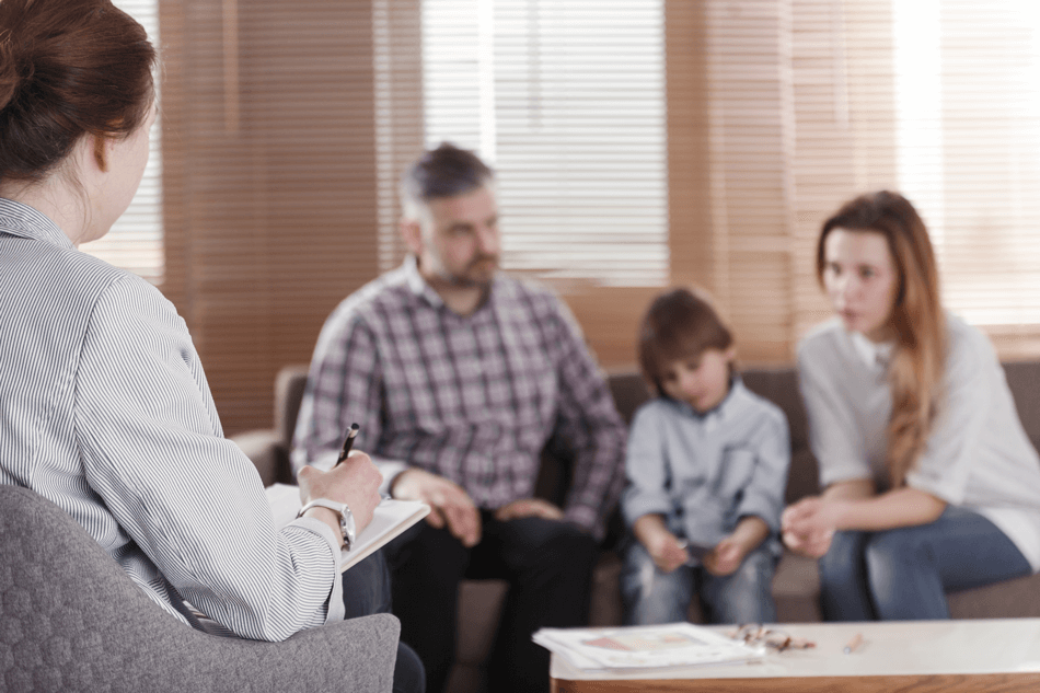 Pai, mãe e filho conversando com uma profissional sobre TDAH - Cellera Farma.