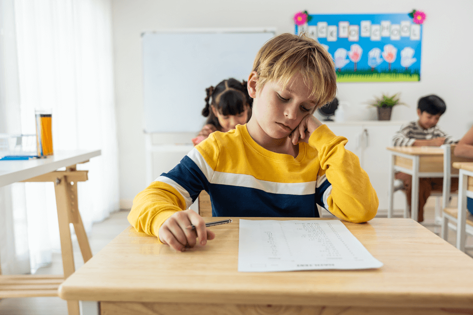 Criança com TDAH sentindo dificuldade de concentração em uma tarefa na sala de aula – Cellera Farma.